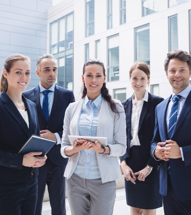 Portrait of confident businesspeople standing outside office building